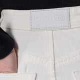 Close-up of the back waistband and logo patch on the distressed jeans for women.