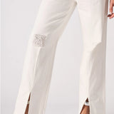 Lower body shot highlighting the straight leg cut, frayed distressed patches, and ankle splits.