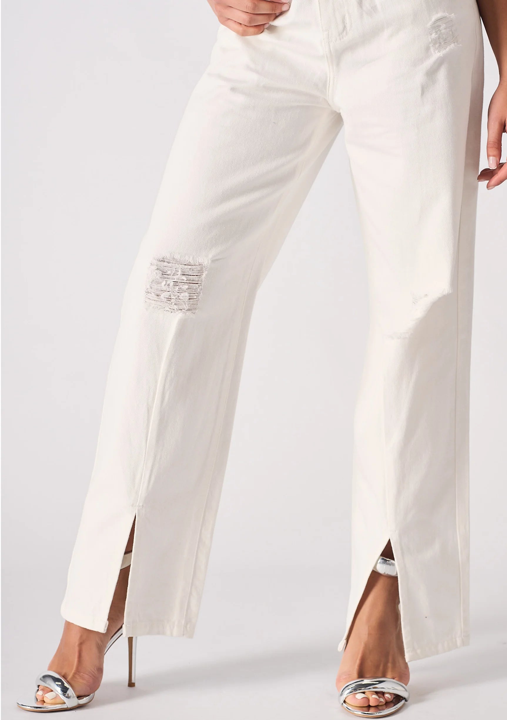 Lower body shot highlighting the straight leg cut, frayed distressed patches, and ankle splits.