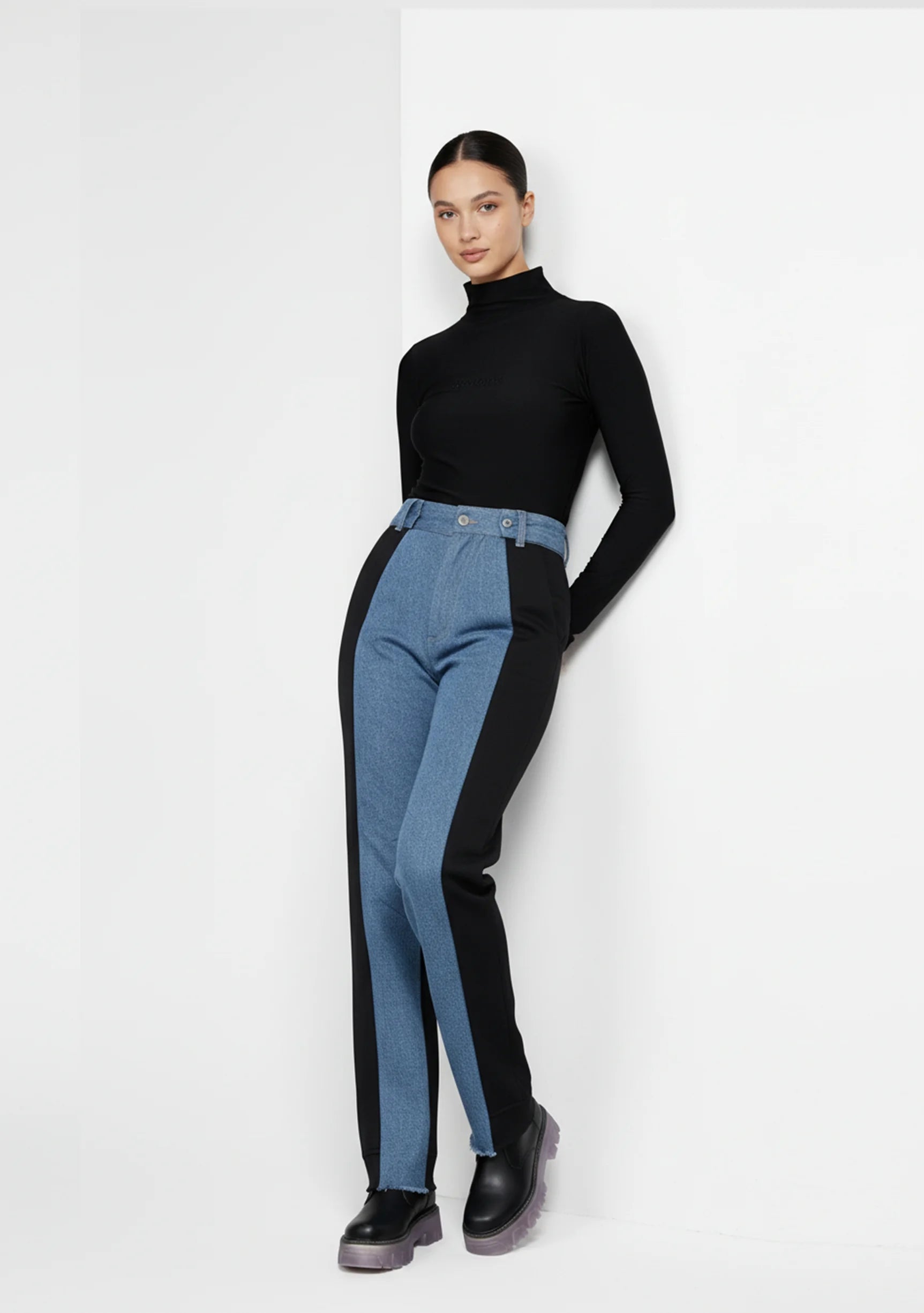 Angled side view of dual wash high-rise denim pants showing the transition from light blue to black.