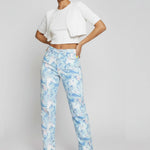 Model standing with hands on hips wearing female abstract pattern split hem jeans.