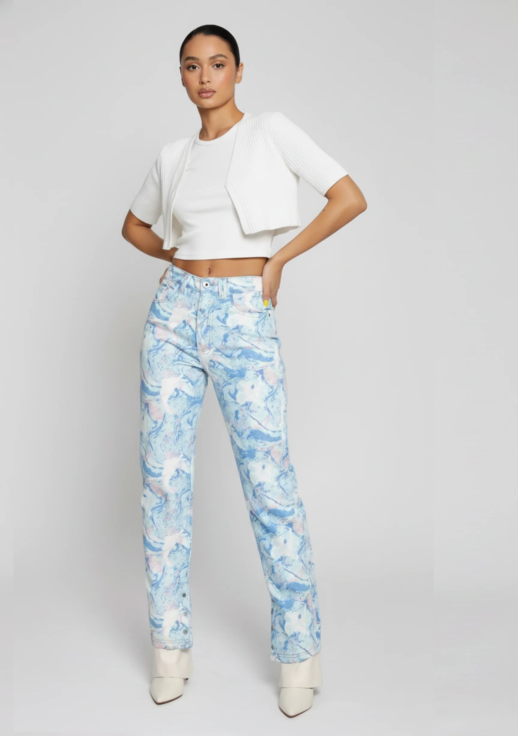 Model standing with hands on hips wearing female abstract pattern split hem jeans.