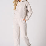 Full length shot of a woman walking in a stone graphic tracksuit set