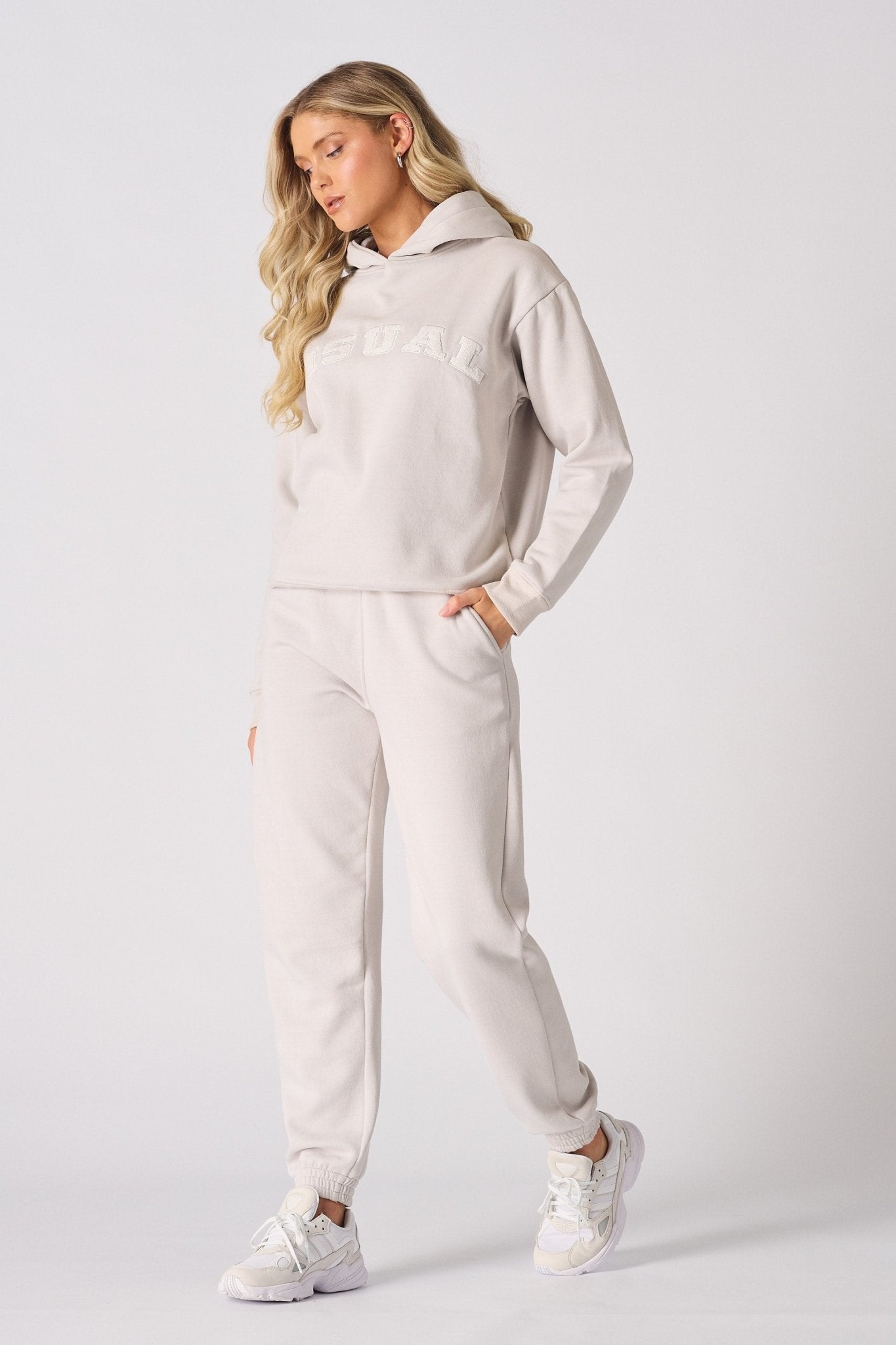 Full length shot of a woman walking in a stone graphic tracksuit set
