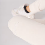 Close up showing the soft texture and fit of the female white sweatpants.