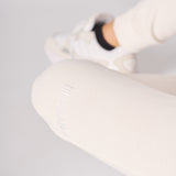 Close up showing the soft texture and fit of the female white sweatpants.