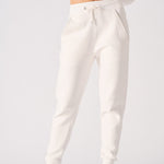 A woman wearing stylish female white sweatpants in a front view shot.