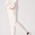 Side profile of a model walking in comfortable female white sweatpants.