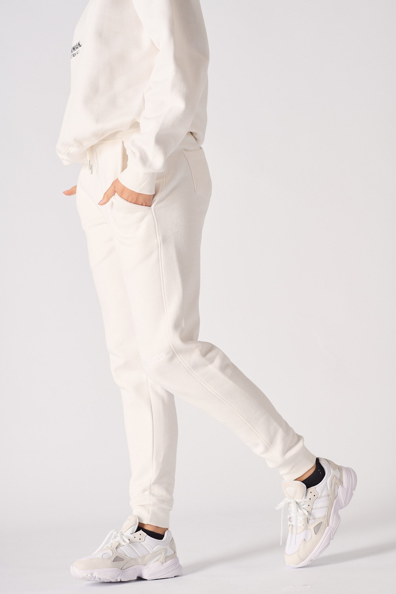 Side profile of a model walking in comfortable female white sweatpants.