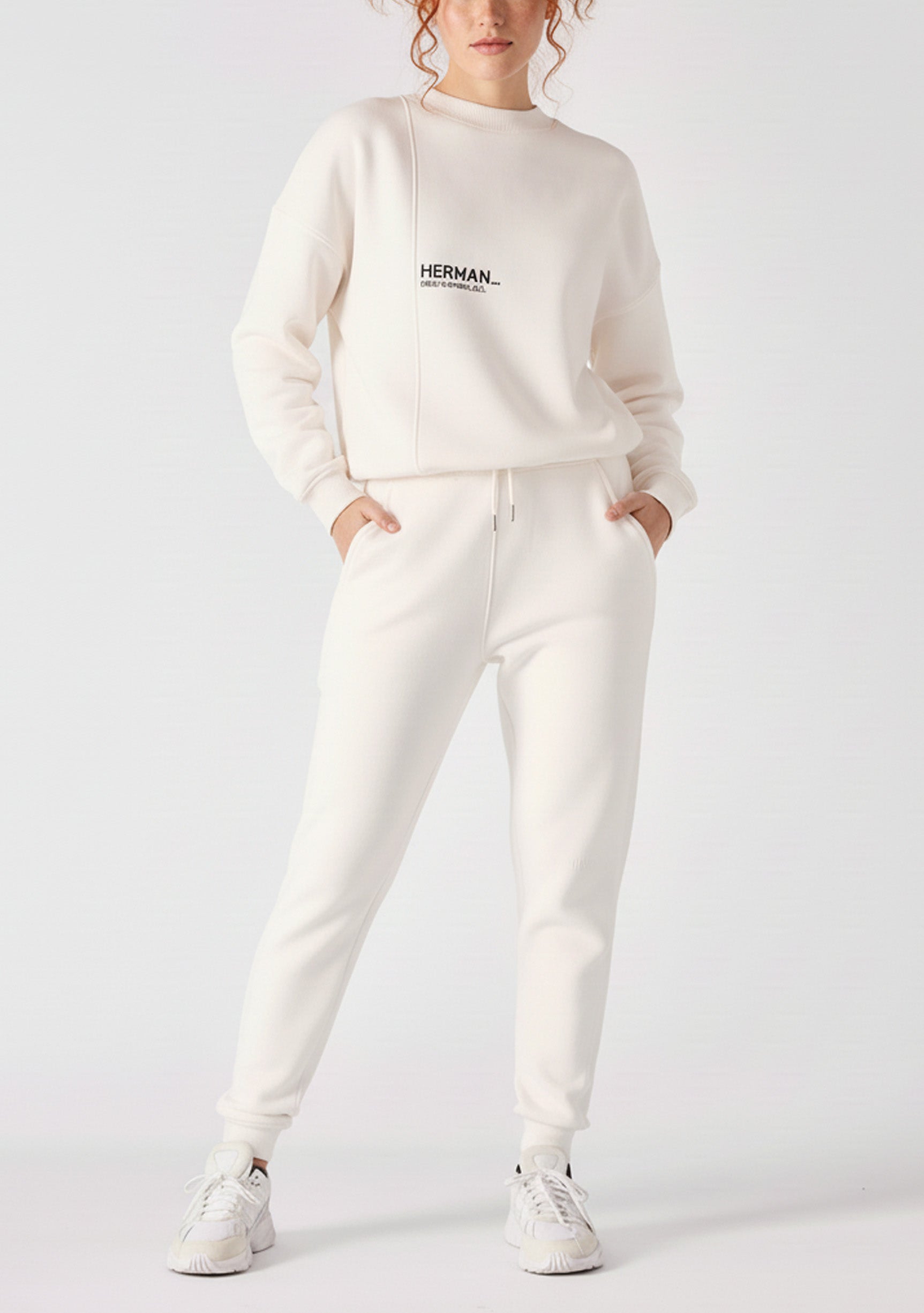 Front view of a model walking while wearing premium female white sweatpants.