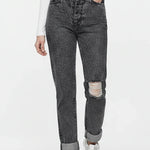 Person wearing gray distressed jeans and white sneakers on a white background