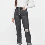 Person wearing a white long-sleeve top and gray distressed jeans on a white background