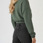 Rear view of a dark green cropped half zip sweatshirt showing the relaxed fit