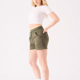 A woman wearing a white headband and green jogger shorts for a casual outfit