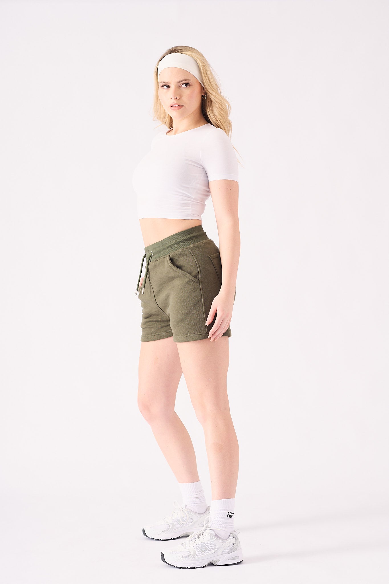 Side profile of a woman posing in comfortable green jogger shorts for a relaxed look