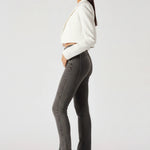 Side profile view of model wearing high-waisted acid grey bootcut denim