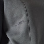 close up of embroidered logo on grey crew neck jumper