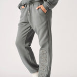 A model posing in premium grey cuffed joggers womens with white trainers.