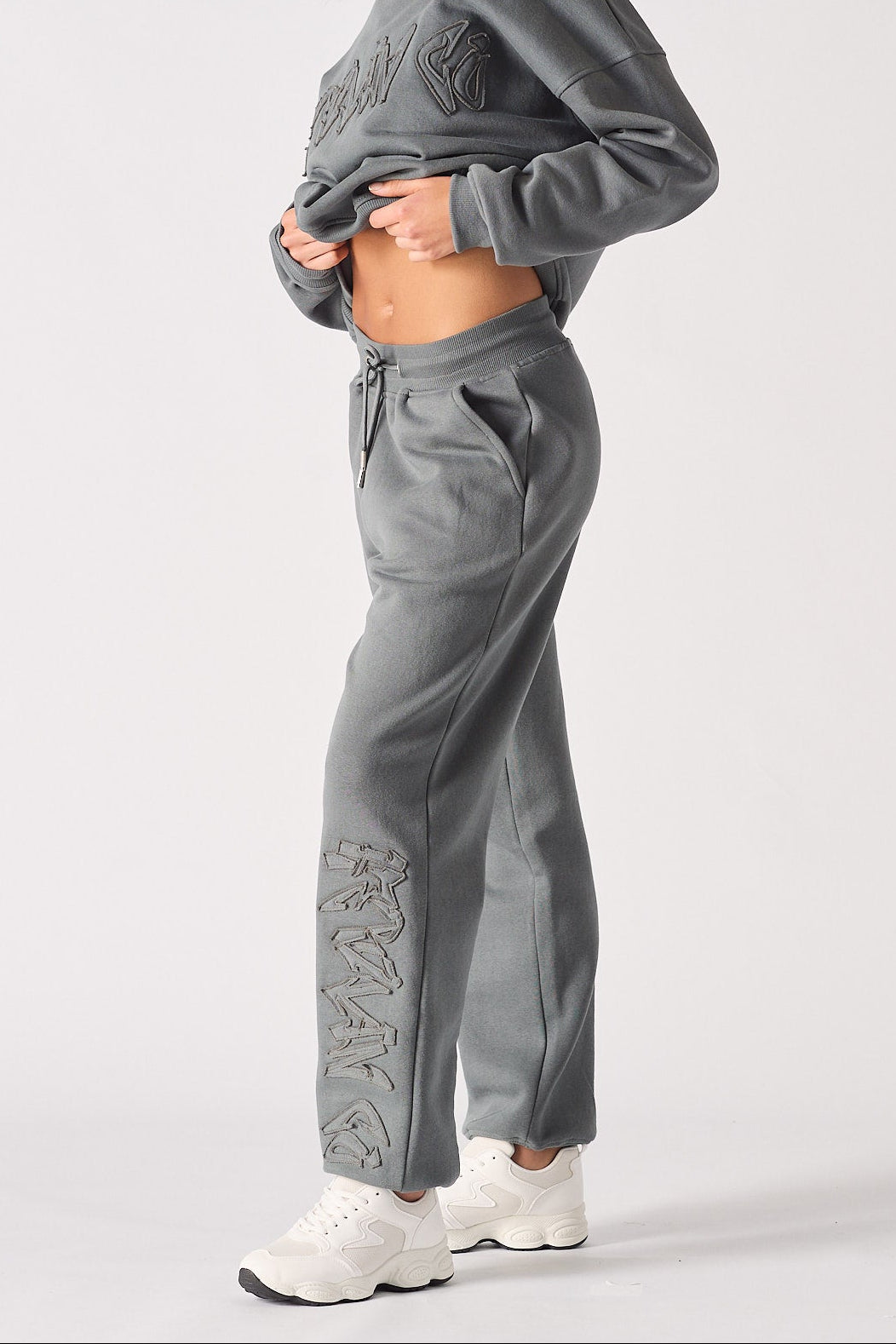 Side profile showing the relaxed silhouette of the grey cuffed joggers womens.