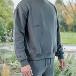side profile showing relaxed fit in grey oversized crew neck jumper