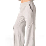 Side profile of a model posing in comfortable grey seam detail wide leg joggers women.