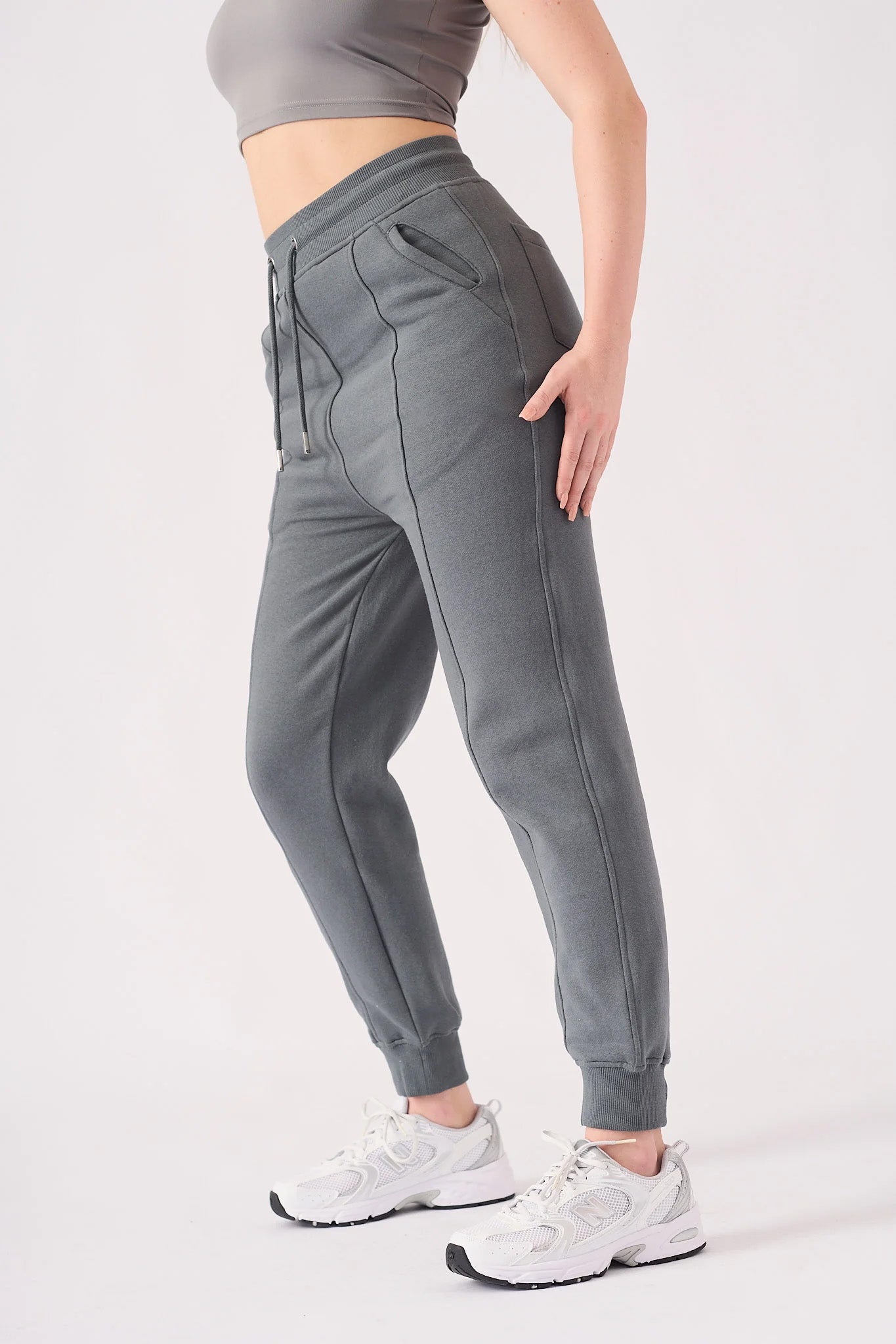Angled view of a model posing in the premium grey tapered joggers womens.