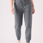 A woman wearing stylish grey tapered joggers womens in a front view shot.