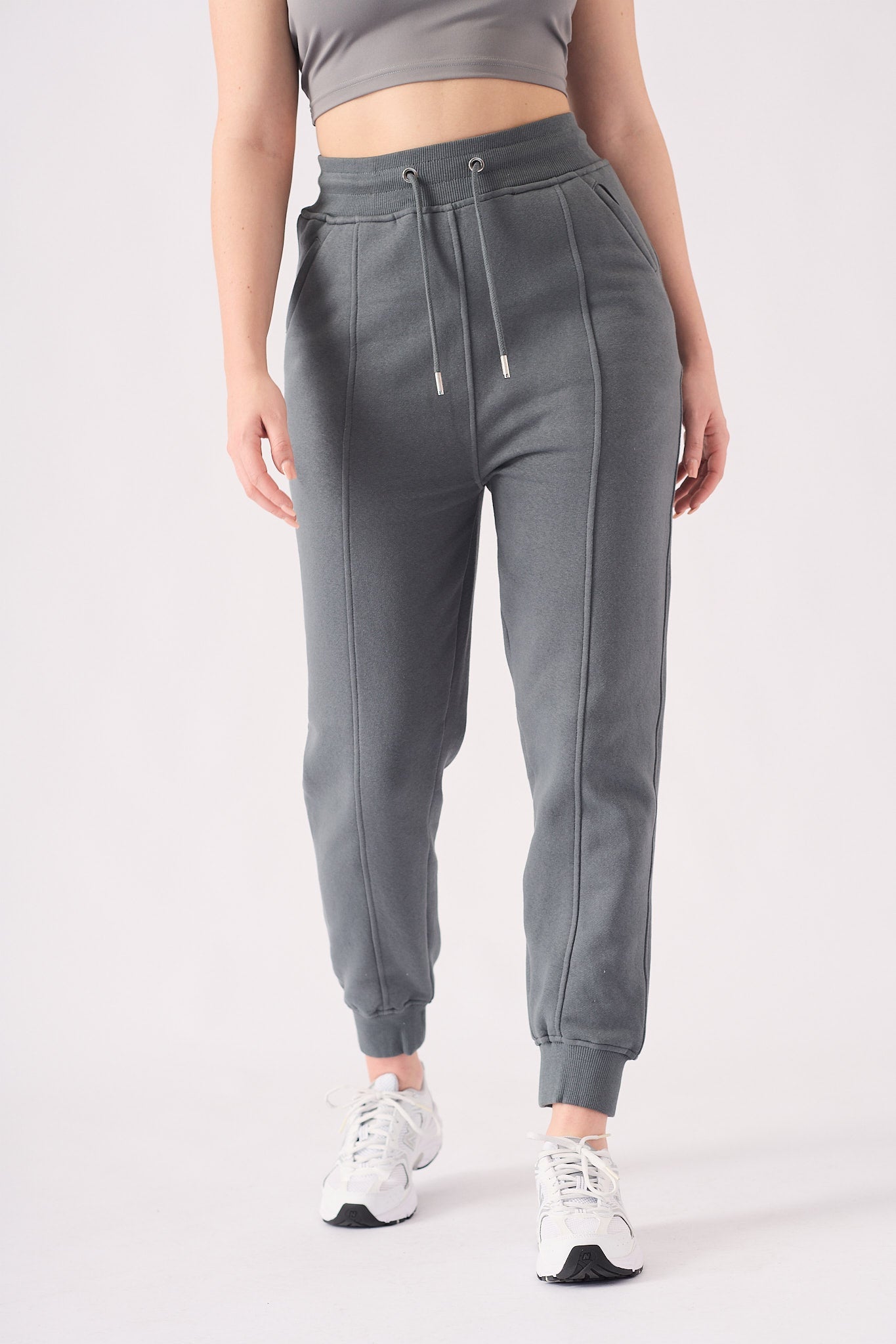 A woman wearing stylish grey tapered joggers womens in a front view shot.