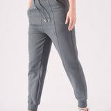 A model walking forward while wearing high quality grey tapered joggers womens.