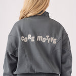 Detailed shot of the core motive branding on the back of a grey hoodie