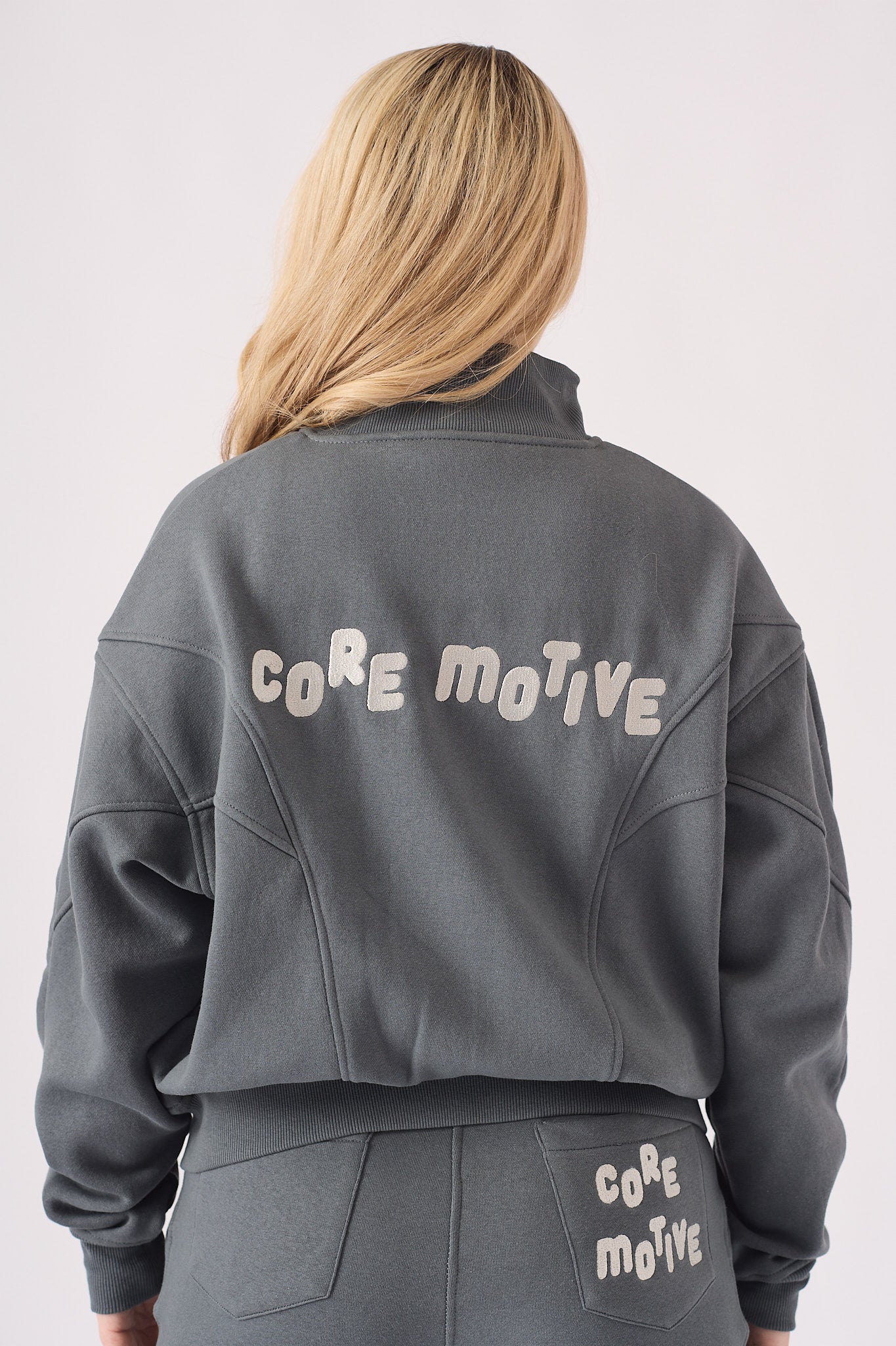 Detailed shot of the core motive branding on the back of a grey hoodie