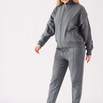 Full front view of a woman wearing a grey zip up hoodie for women with white trainers