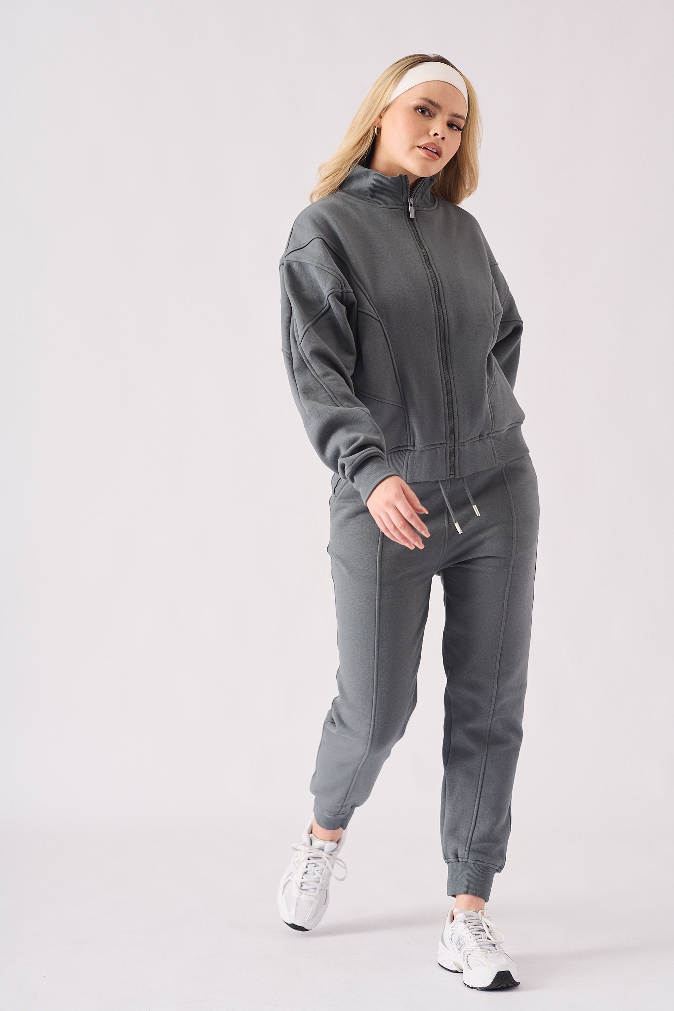 Side profile view of a model walking in a comfortable grey zip up hoodie