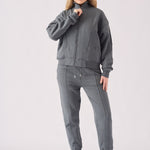 Close up shot of a woman adjusting the zip on a grey funnel neck hoodie