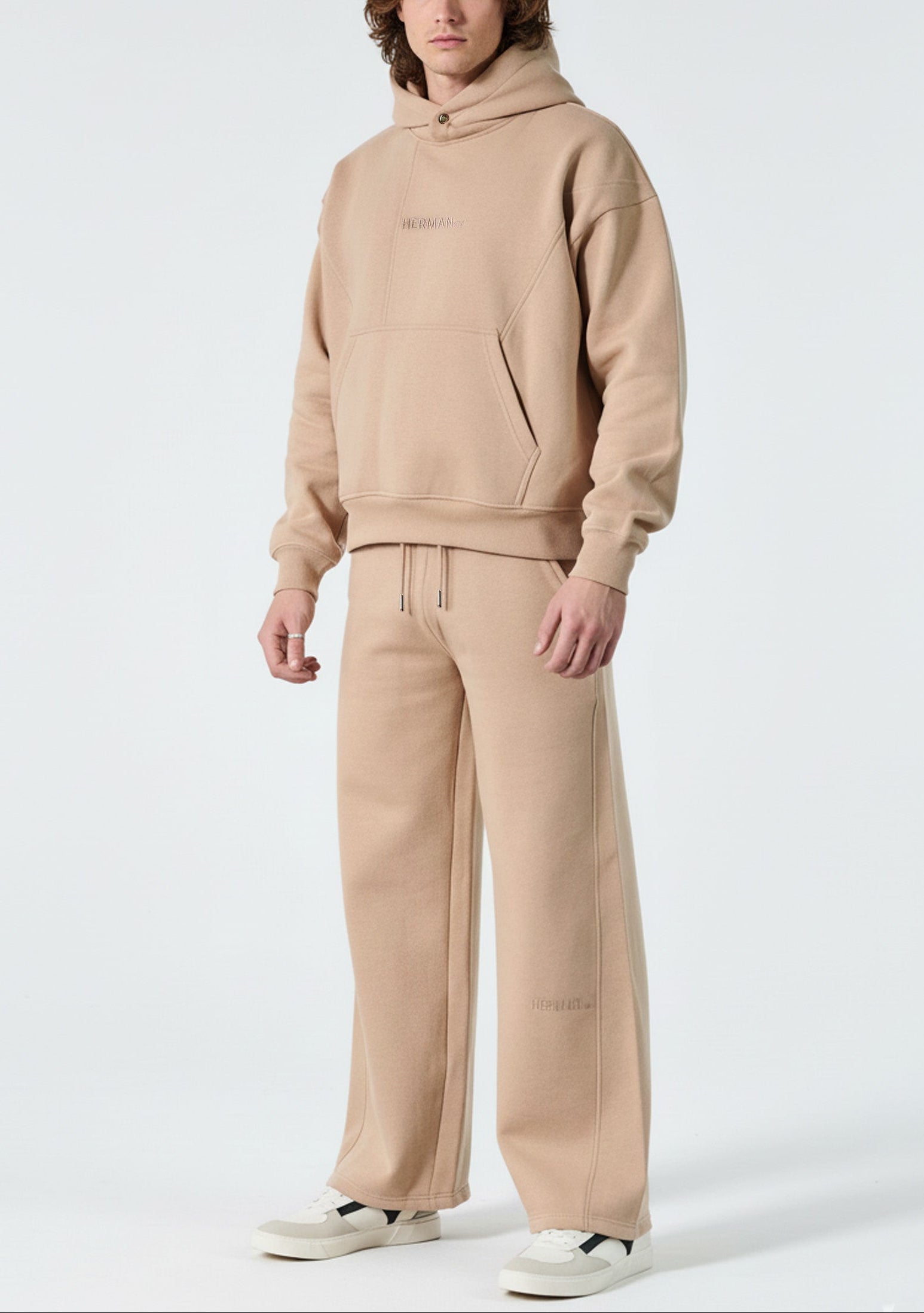 Angled view of the Herman men's beige popper neck hoodie, highlighting the oversized silhouette.