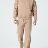 Front view of a model wearing the Herman men's beige popper neck hoodie and wide-leg joggers.