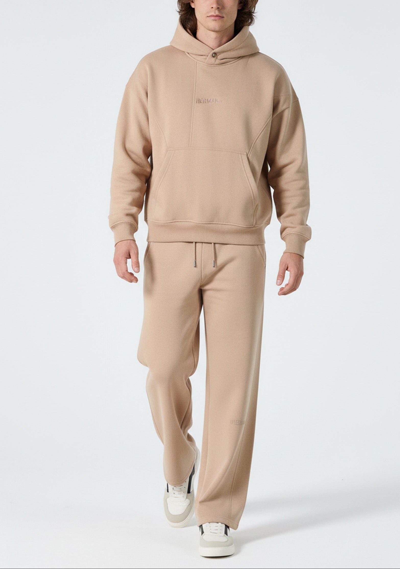 Front view of a model wearing the Herman men's beige popper neck hoodie and wide-leg joggers.