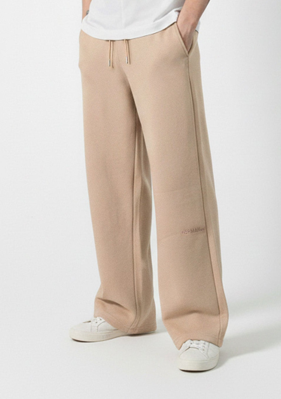 Angled front view showing the relaxed silhouette of the Herman men's beige joggers.