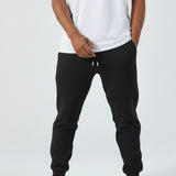 Front view of the Herman men's black tapered joggers styled with a white t-shirt.