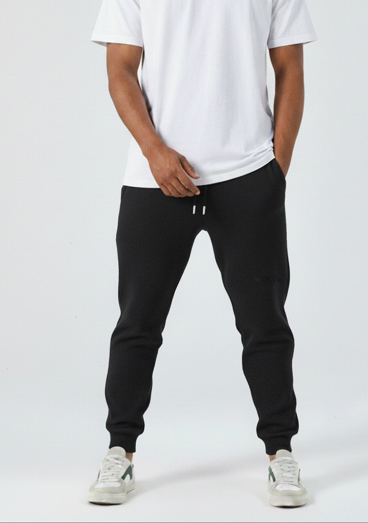 Front view of the Herman men's black tapered joggers styled with a white t-shirt.