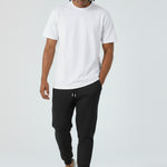Model walking in the Herman men's black tapered joggers showing the slim fit.