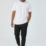 Model walking in the Herman men's black tapered joggers showing the slim fit.