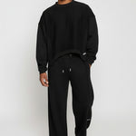 Model styled in the Herman men's black wide-leg joggers with a matching sweatshirt.