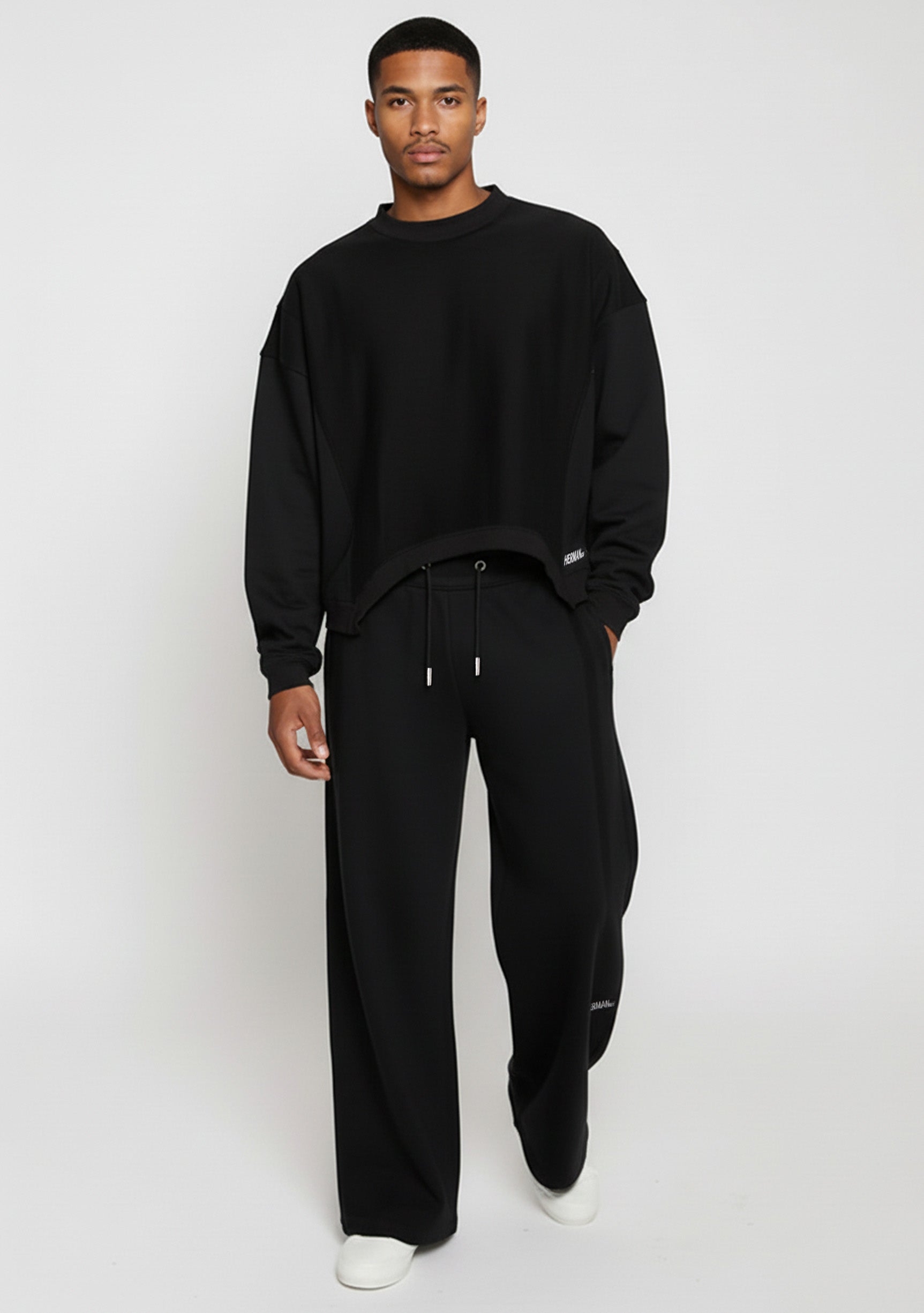 Model styled in the Herman men's black wide-leg joggers with a matching sweatshirt.