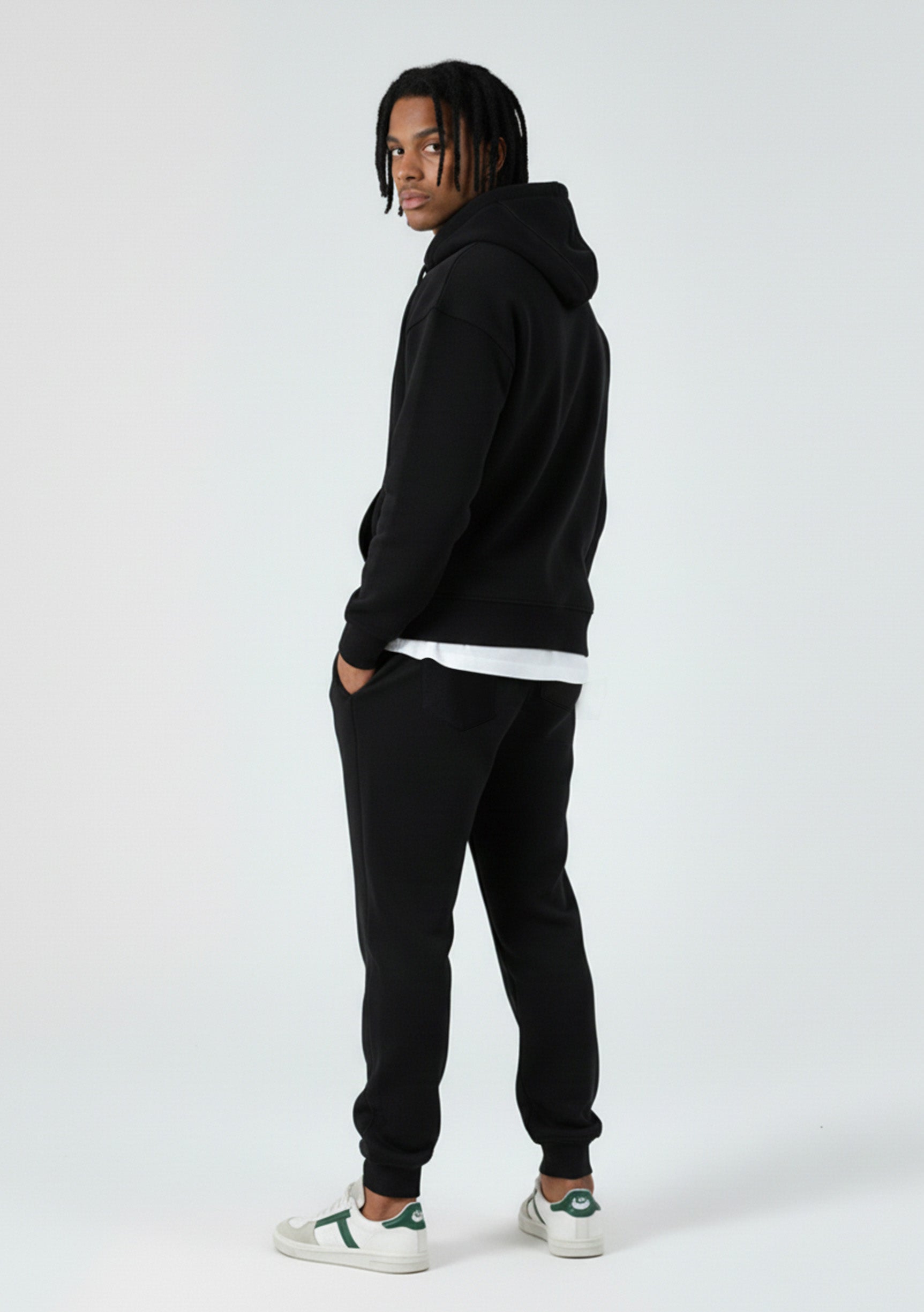 Side view of a model in the Herman men's black zip up hoodie and matching joggers