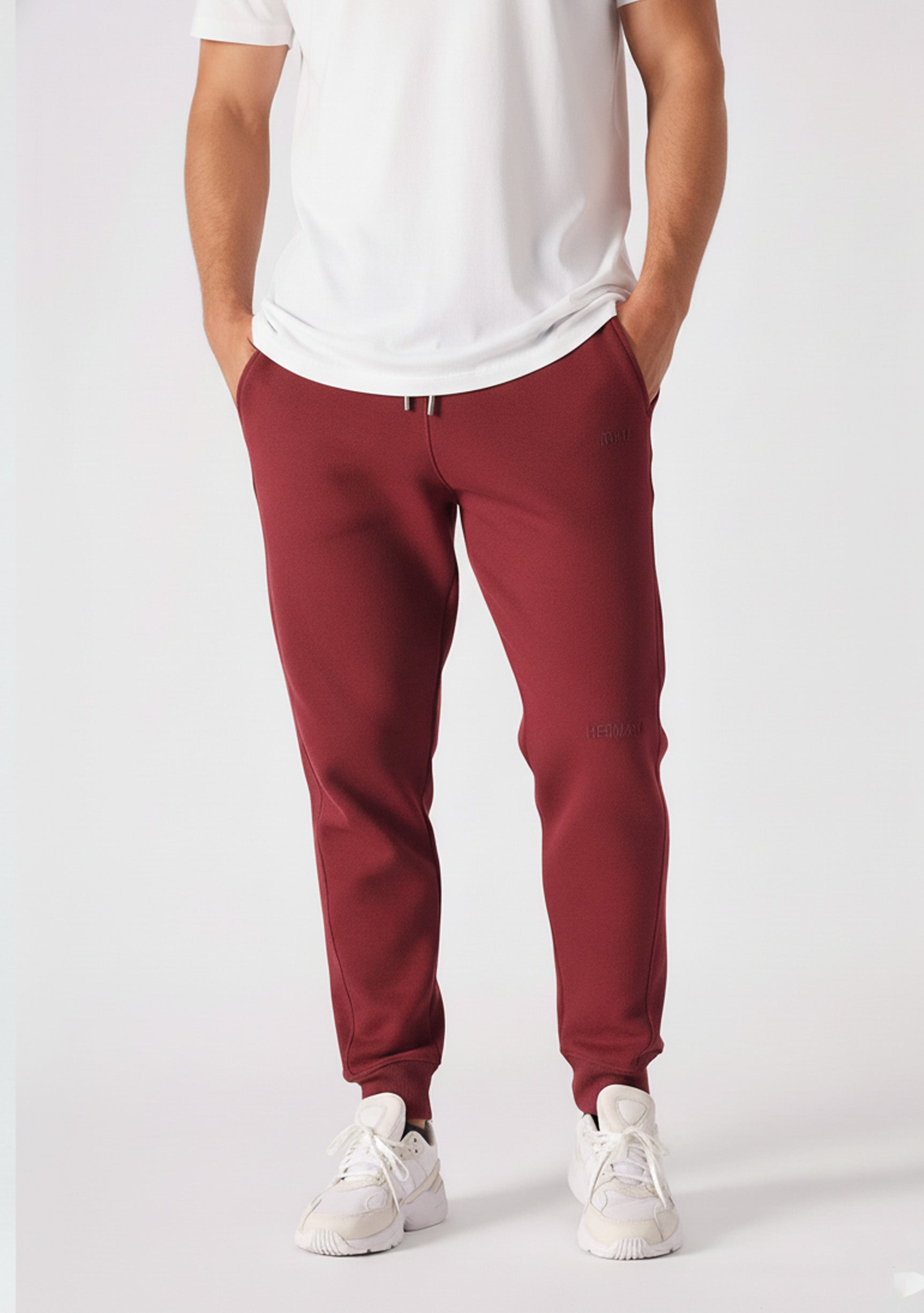 Front view of the Herman men's burgundy tapered joggers styled with a white t-shirt.