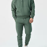 Angled front view of the Herman men's green oversized popper neck hoodie.