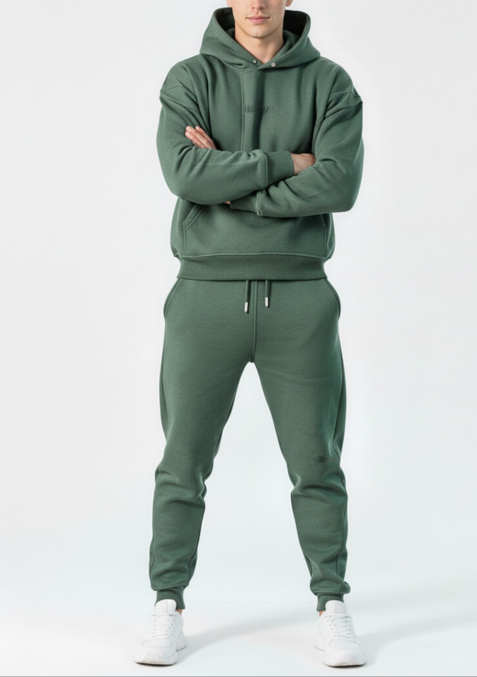 Model styled in the Herman men's green popper neck hoodie with arms crossed.