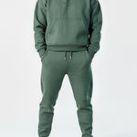 Full front view of a model wearing the Herman men's green popper neck hoodie and matching joggers.