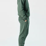 Side profile of the Herman men's green popper neck hoodie and joggers.